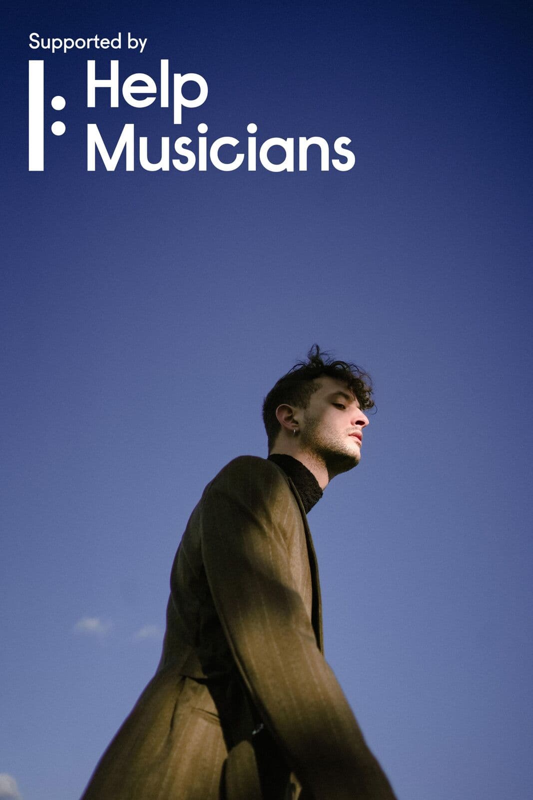 Davide De Santis, supported by Help Musicians UK, photographed against a deep-blue sky